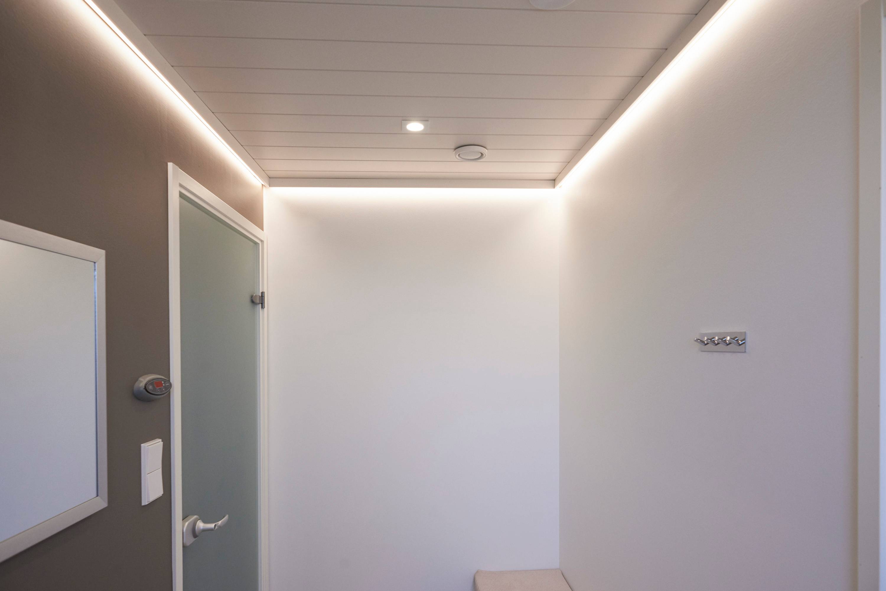 Le couloir est éclairé par une bande LED à éclairage indirect derrière une bande de plafond et un spot Fixed Cant. Ledstore.fi